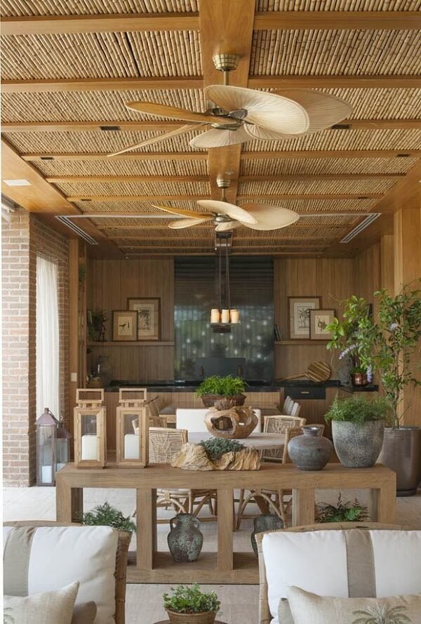 Decoração rústica com pergolado de bambu e sofás modernos