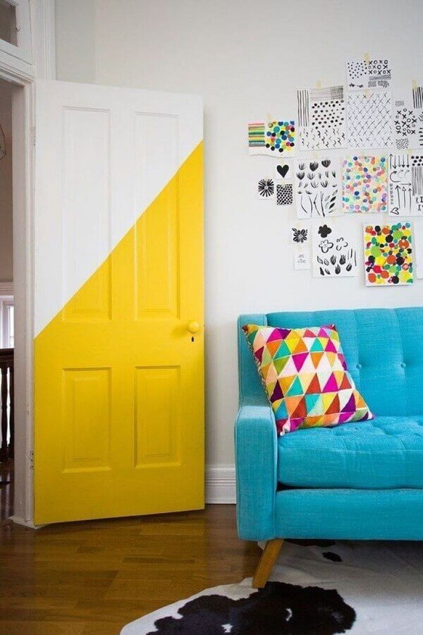 Decoração simples para sala colorida com sofá azul e porta meia pintada Foto OkChicas