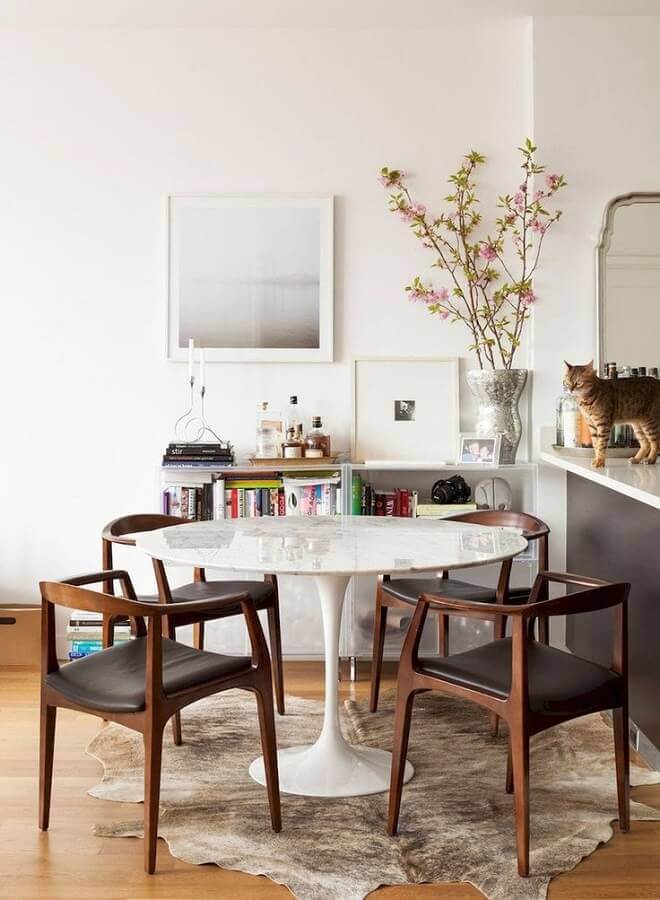 Decorada o simples de sala de jantar com cadeira almofadada e tapete de couro Foto Constance Zahn