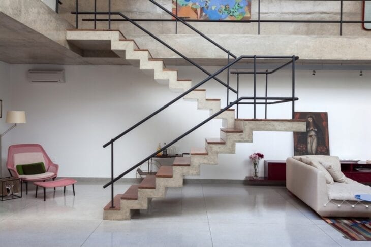 Escadas modernas de concreto com guarda corpo de ferro preto 