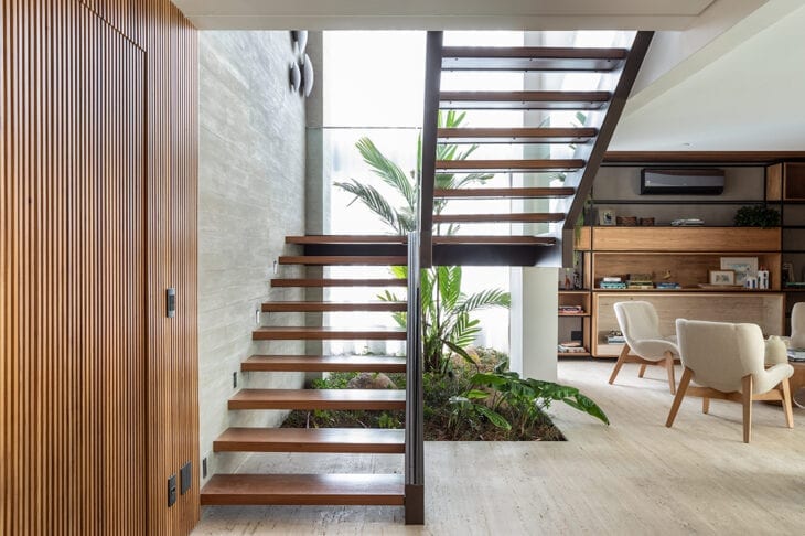 Escadas modernas de madeira com sala de estar em tons neutros chiques