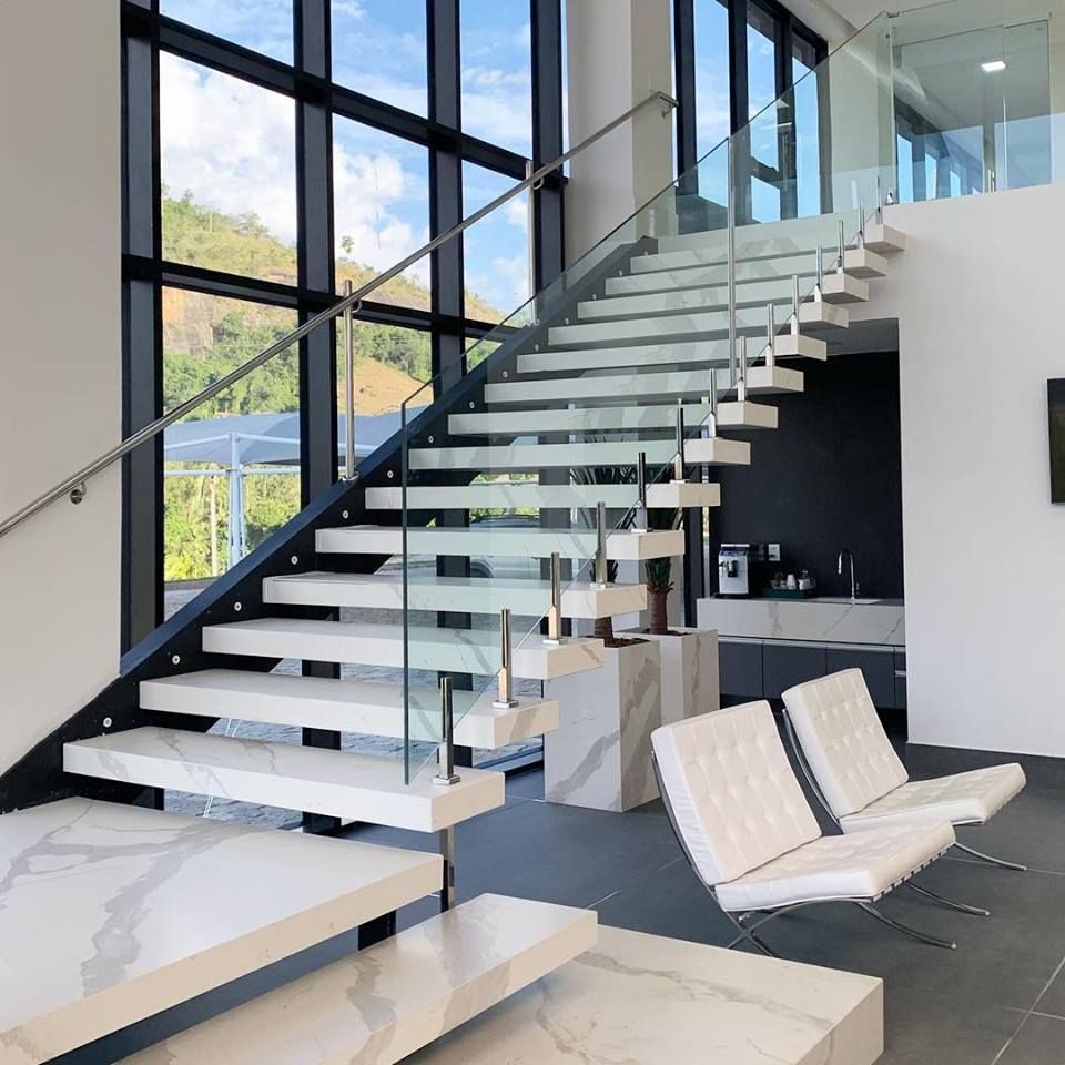 As escadas modernas de mármore com proteção de vidro são perfeitas para casas grandes e iluminadas