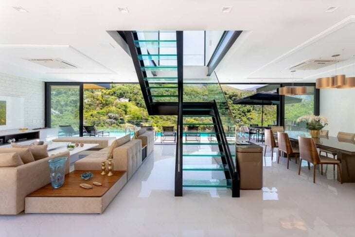 Escadas modernas de vidro e ferro na casa de conceito aberto