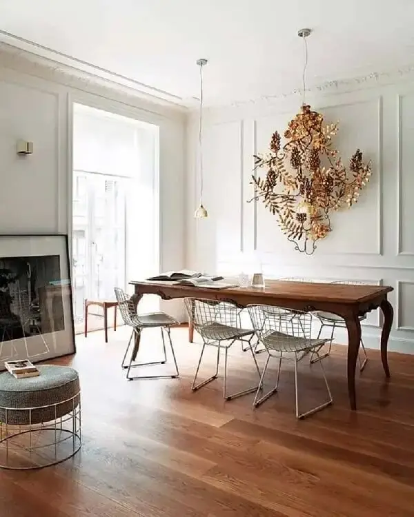 Mesa de madeira, cadeiras cromadas e boiserie sala decoram o espaço. Fonte: Erika Brechtel