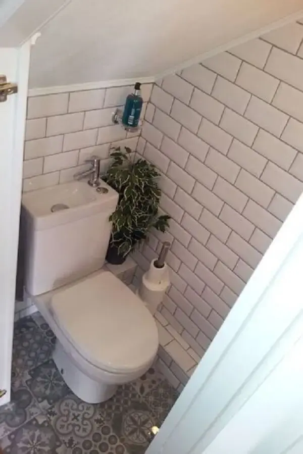 O revestimento branco do banheiro embaixo da escada traz a sensação de amplitude. Fonte: Hannah Keates