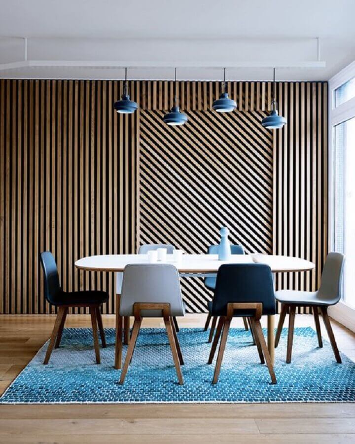 Parede ripada de madeira para sala de jantar decorada com tapete e cadeiras azuis Foto Decor Fácil