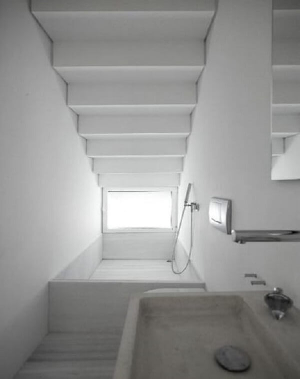 Projeto ousado de banheiro pequeno embaixo da escada com banheira. Fonte: Decorei