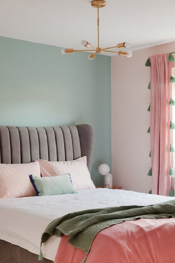 Quarto delicado com parede verde pastel e cortinas cor de rosa