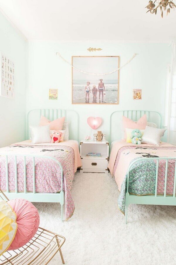 Quarto infantil com cama verde água e roupa de cama rosa