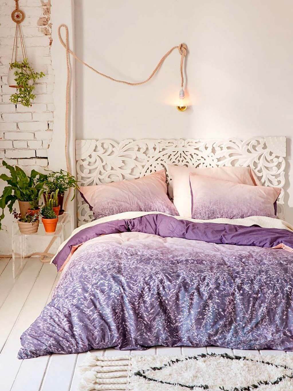 Quarto lilás aconchegante com decoração de flores e roupa de cama confortável