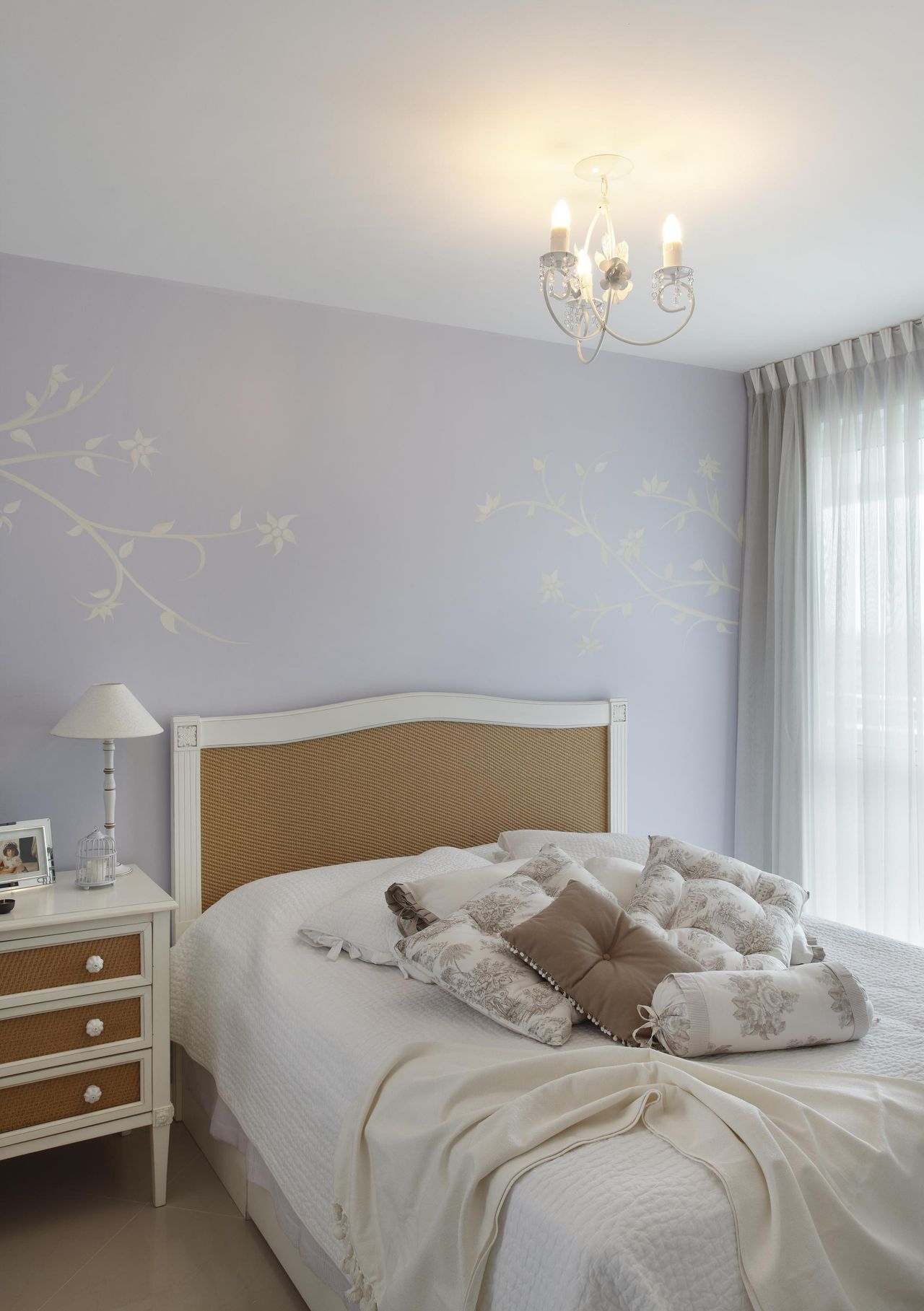 Quarto lilás com papel de parede floral e roupa de cama chique