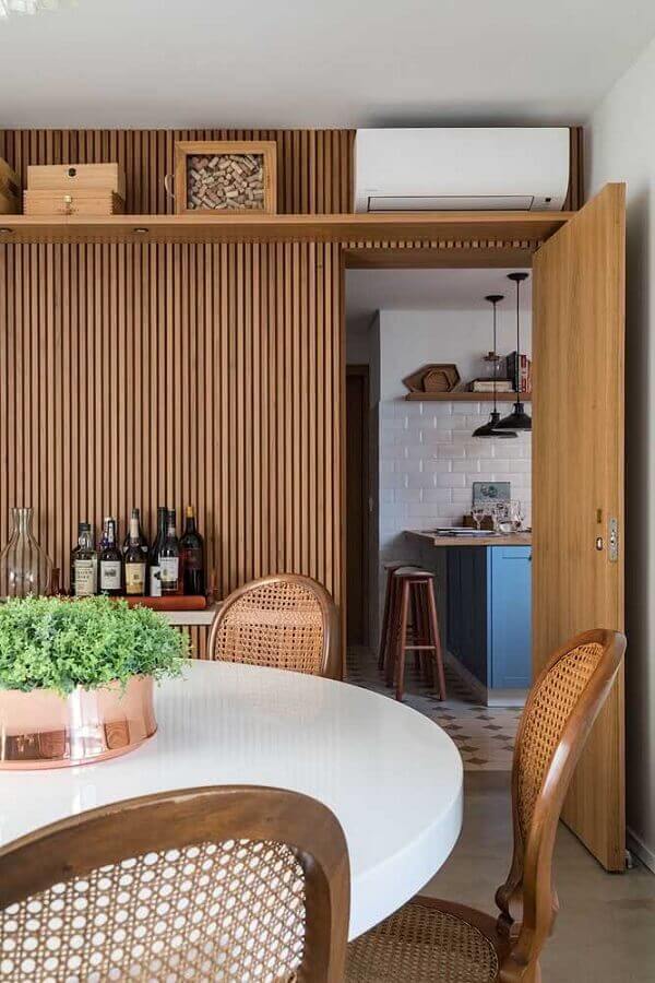 Ripas de madeira na parede de sala de jantar decorada com mesa redonda Foto Casa Vogue