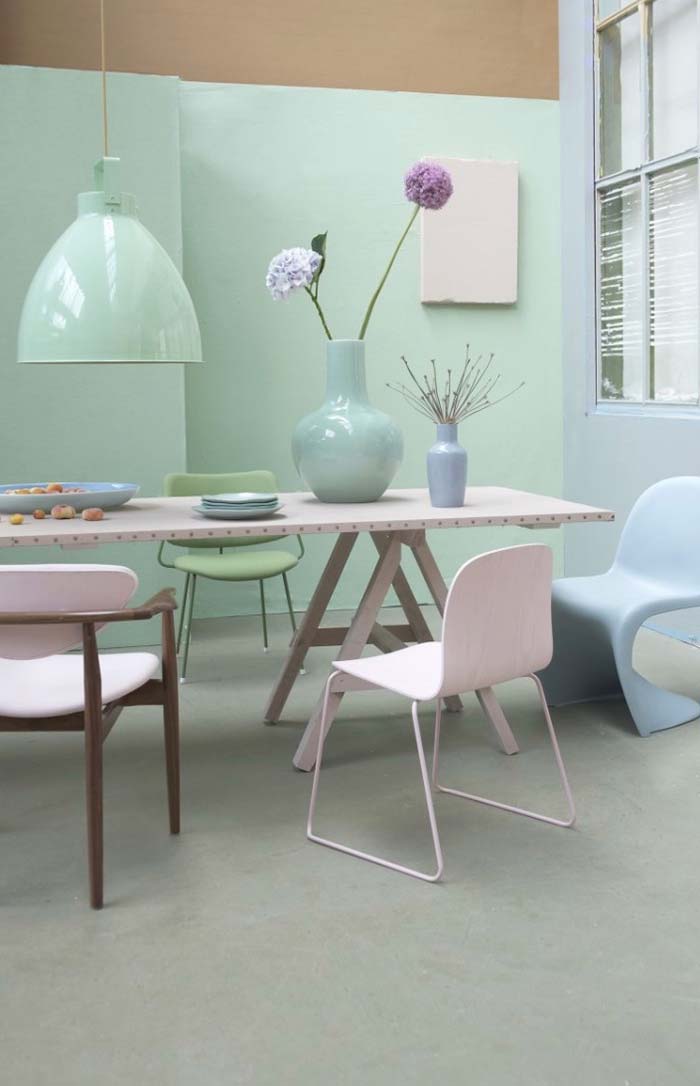 Sala com parede verde pastel e mesa rosa claro