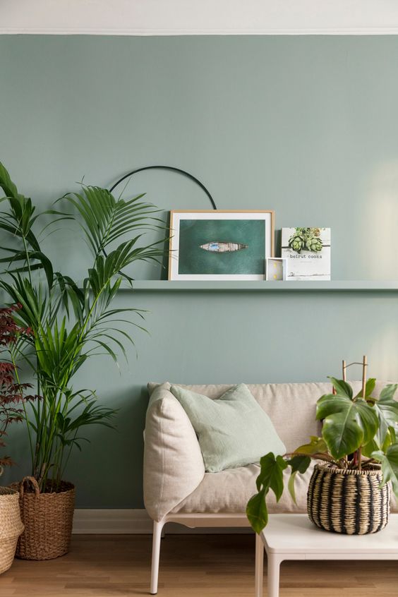 Sala com parede verde pastel e sofá bege