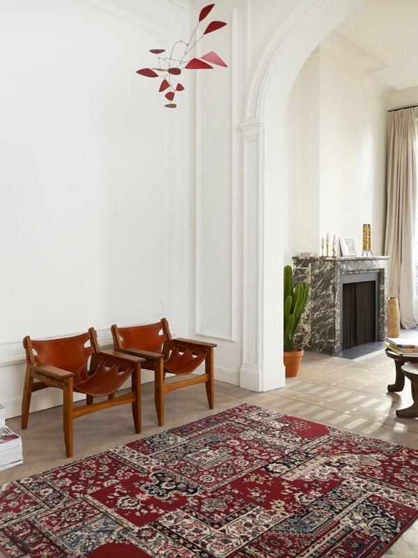 Sala com tapete belga vermelha e poltrona de madeira