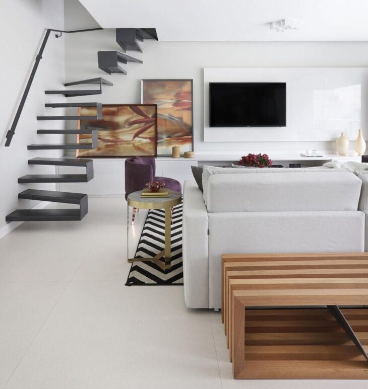 Sala de estar com escadas modernas pretas em contraste com o ambiente branco
