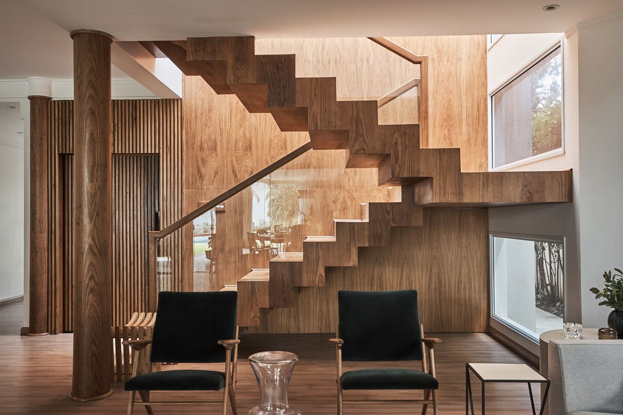 Sala de estar de madeira com escadas modernas iluminadas