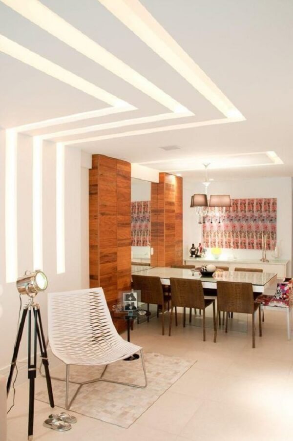 Sala de jantar com forro de gesso do tipo rastro de luz na parede e teto 