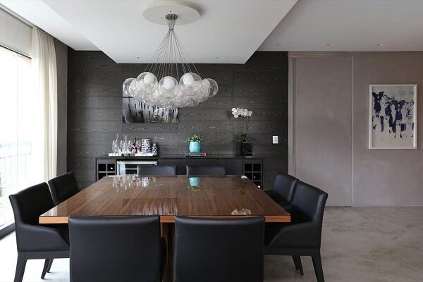 Sala de jantar com parede preta e cadeiras de couro