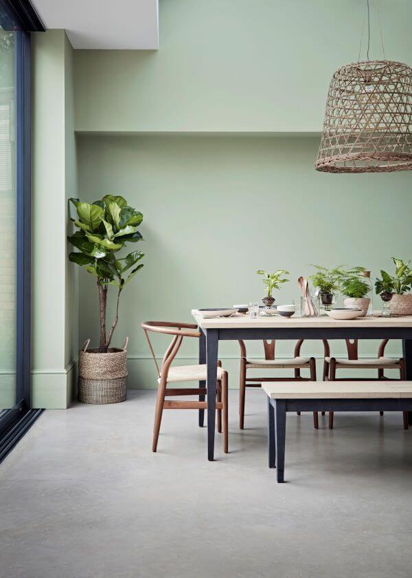Sala de jantar com parede verde sage e móveis de madeira