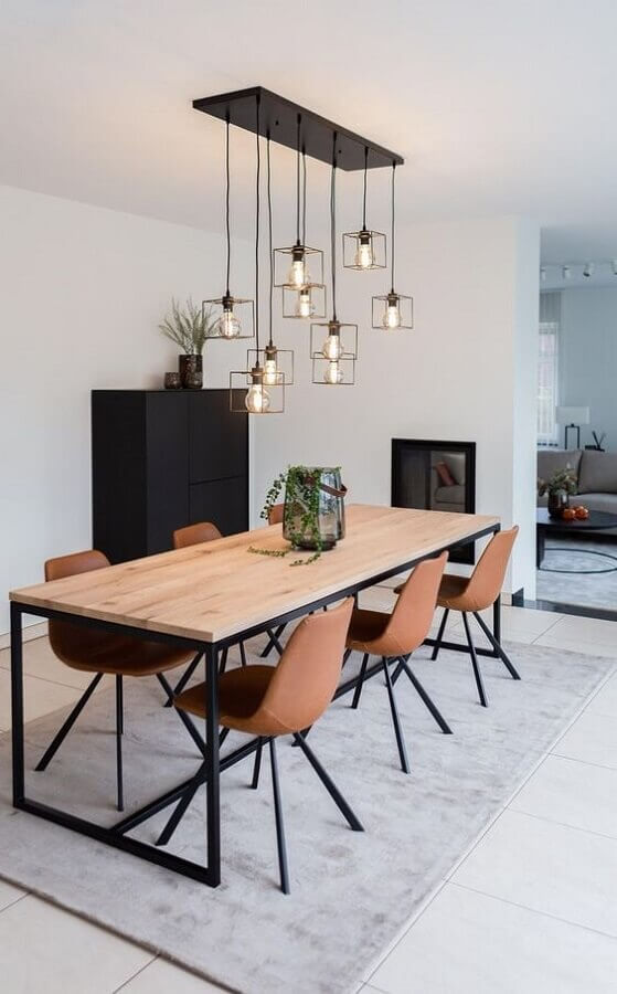 Sala de jantar decorada com mesa de madeira e lustre aramado cobre Foto Futurist Architecture