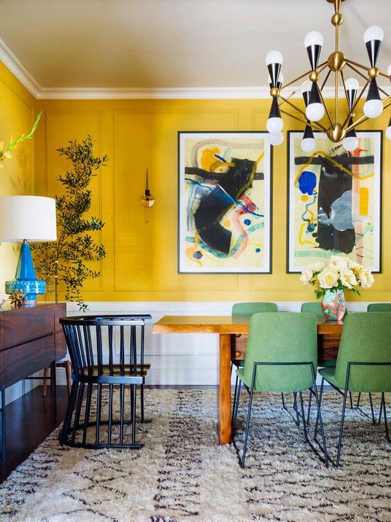 Sala de jantar grande decorada com tons de amarelo com cadeira verde