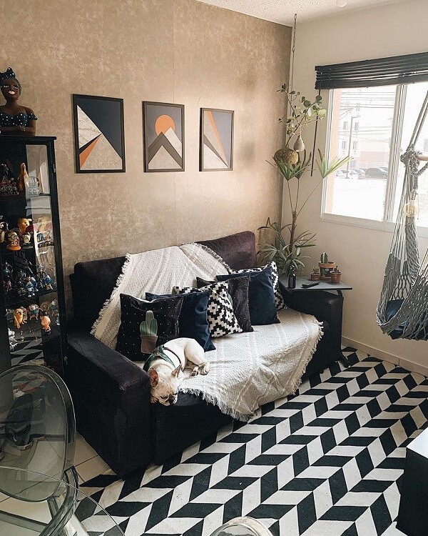 Sala preta e branca com tapete chevron e almofadas no sofá