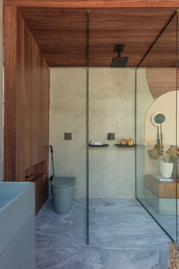 Tipos de chuveiro para banheiro com revestimento de madeira e metais pretos