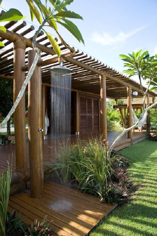Varanda com pergolado de bambu e cantinho com chuveiro externo