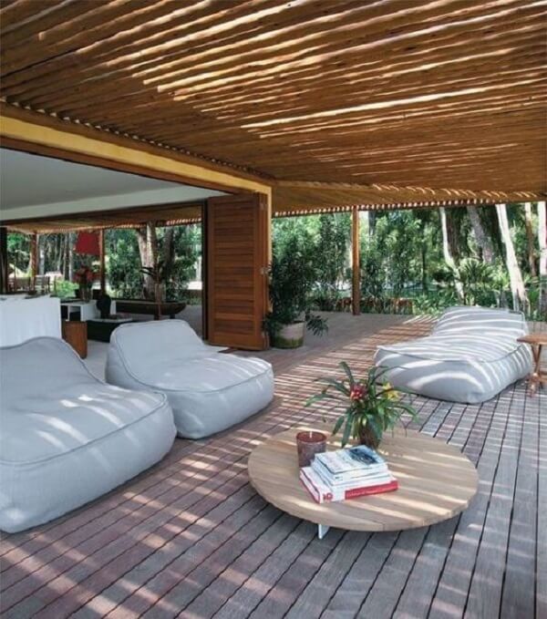 Varanda com pergolado de bambu e móveis confortáveis 
