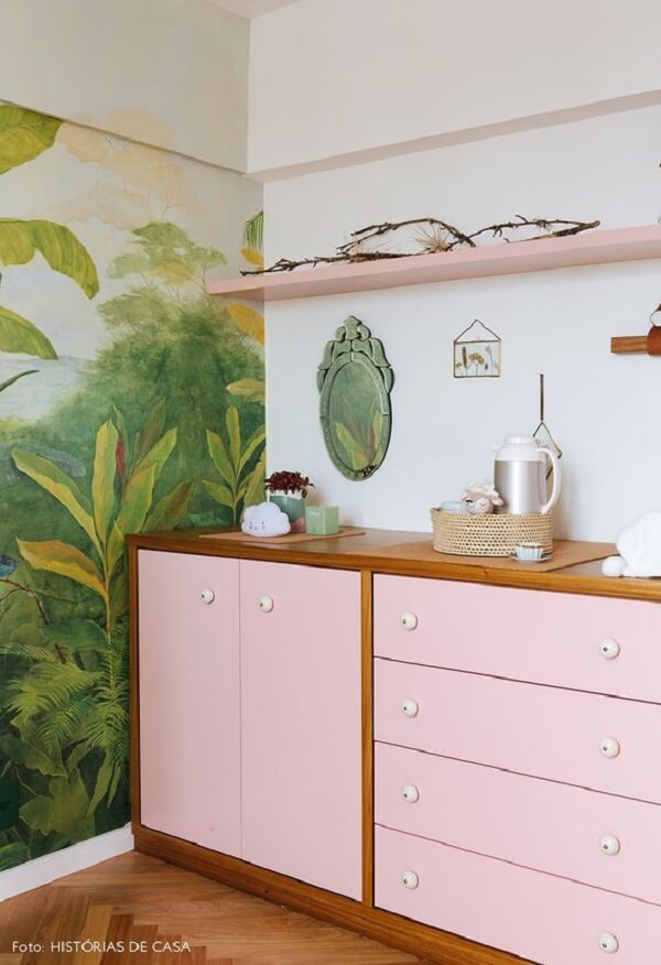 Cômoda colorida rosa e madeira com papel de parede verde