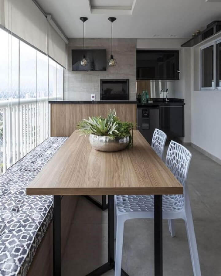 Área gourmet em espaço pequeno decorado com cadeira branca para mesa com banco de madeira Foto Rúbia Vieira