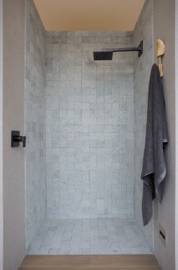 Banheiro cinza com chuveiro preto moderno 