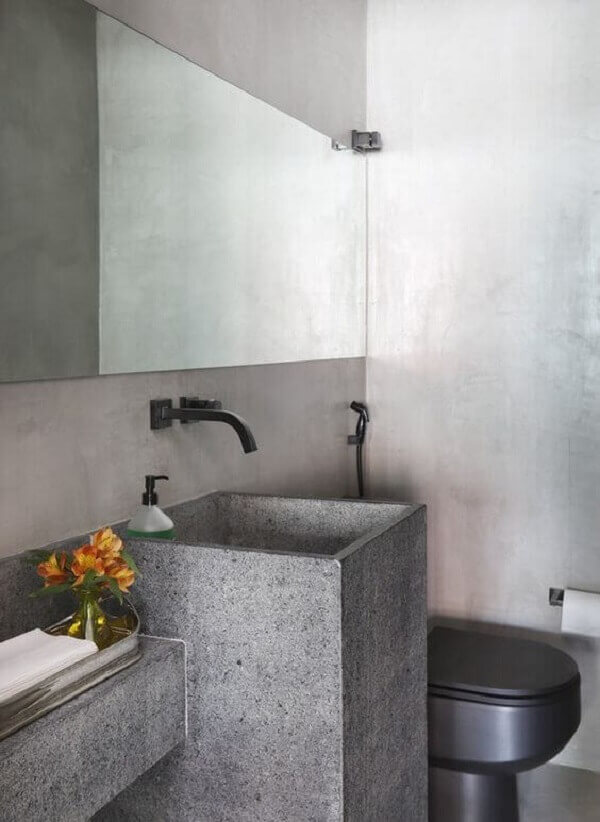 Banheiro cinza com cuba de porcelanato esculpida e torneira de parede preta