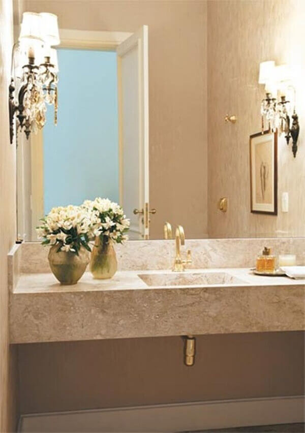 Banheiro com bancada de granito claro e torneira cor dourada