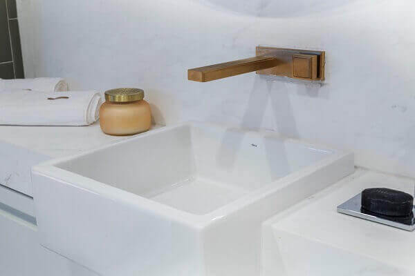 Banheiro com torneira de parede lavabo rose gold