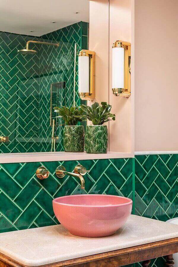 Banheiro verde moderno com cuba de porcelanato cor de rosa e torneira de parede dourada