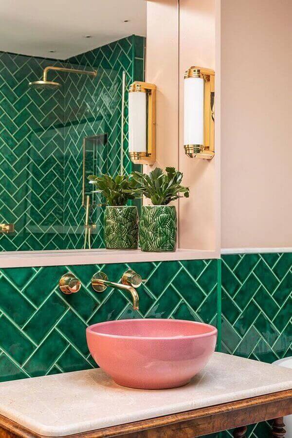 Banheiro verde moderno com cuba de porcelanato cor de rosa e torneira dourada