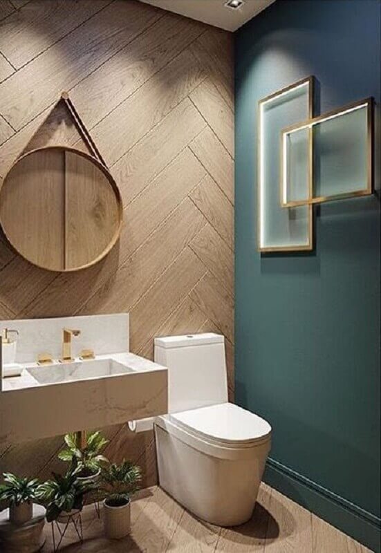 Banheiro verde moderno decorado com espelho redondo e revestimento de madeira Foto Pellmell Creations