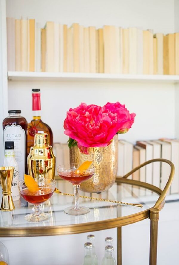 Bar cor dourada com vaso de flor rosa na decoração
