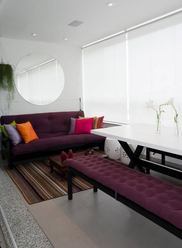 Cortina branca persiana e móveis roxos na varanda