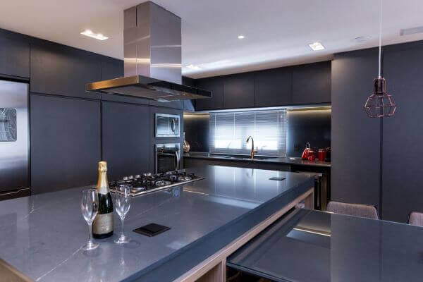 Cozinha com bancada de mármore cinza azulado e armários combinando
