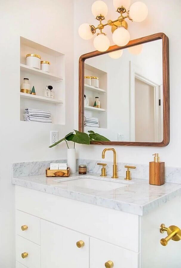 Decoração clean com detalhes em dourado para banheiro com nicho embutido Foto Archzine