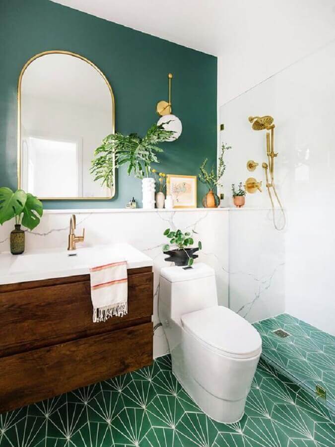 Decoração de banheiro verde e branco com gabinete de madeira e arandela dourada Foto Casa de Valentina