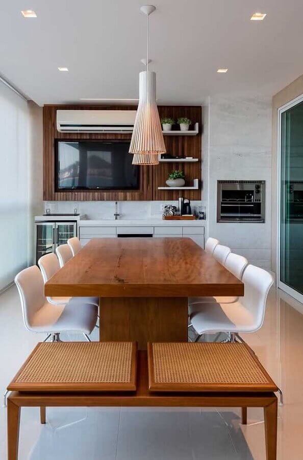 Decoração de espaço gourmet pequeno com mesa de madeira e cadeiras brancas Foto Decostore