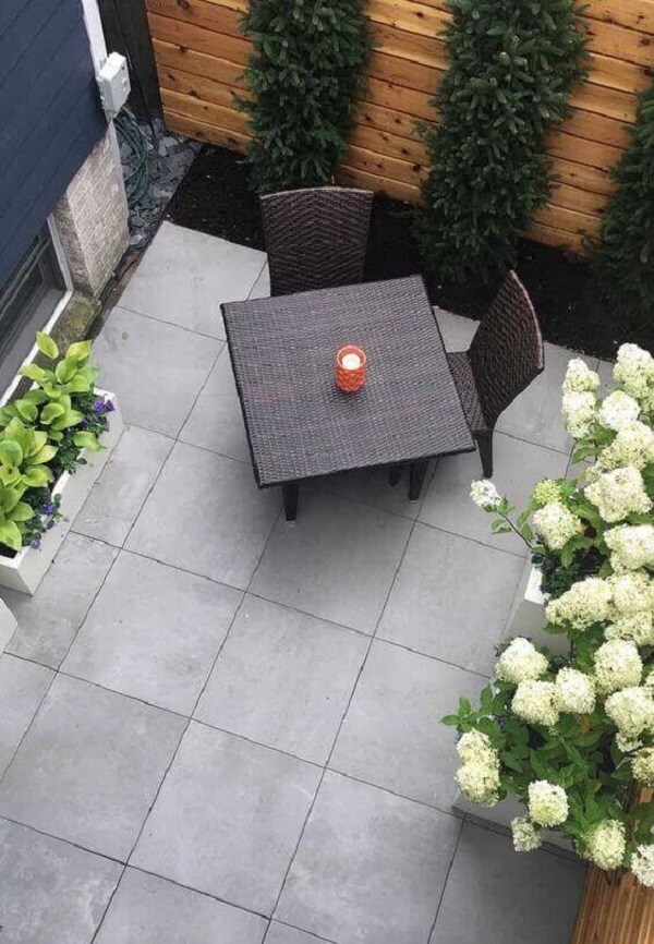 Decoração externa com luminária de jardim na mesa e perto das flores