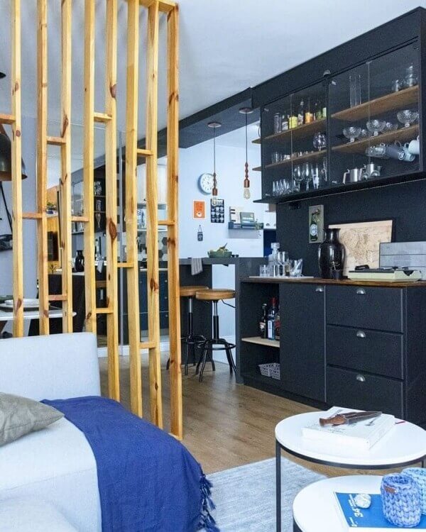 Divisória de madeira para sala com sofá cinza azulado e móveis pretos
