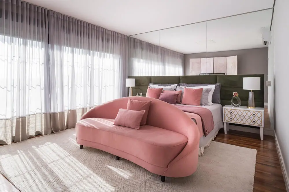 O dormitório do casal recebeu peças do antigo apartamento, como o sofá rosa em frente a cama. Fonte: Kadu Lopes