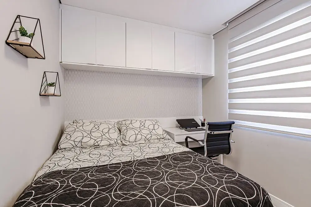 Os armários acima da cama otimizam o espaço no quarto de casal. Projeto por Ana Johns Arquitetura