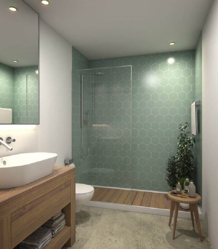 Revestimento hexagonal para decoração de banheiro verde e branco com gabinete de madeira Foto Remodelista
